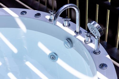 a white sink with two faucets in a bathroom at Villa Noël Hakone Fuji Sauna&Open Air Bath in Hakone