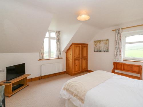 a bedroom with a bed and a flat screen tv at Coorlacka in Ballydivin