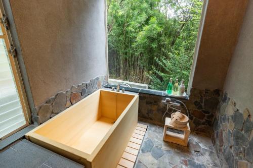a bathroom with a tub and a large window at Villa Noël Hakone Fuji Sauna&Open Air Bath in Hakone