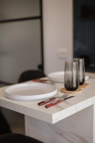 a table with two white plates and glasses on it at 446 Tiny House Shirokë in Široka