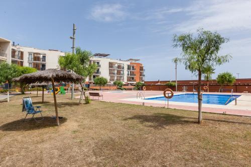 a swimming pool with a chair and an umbrella at Cubelles mar in Cubelles