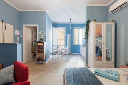 a bedroom with blue walls and a living room at CASA PETRONIO APARTMENTS BOLOGNA CENTER in Bologna