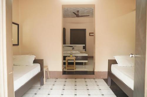 a room with two beds and a mirror at SOWMYA LODGE in Tiruchirappalli