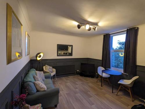 een woonkamer met een bank en een tafel bij St Davids Central Apartment in Exeter
