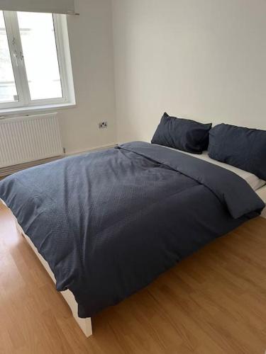a bed with a blue comforter in a bedroom at 3 bedrooms flat Crystal Palace in London