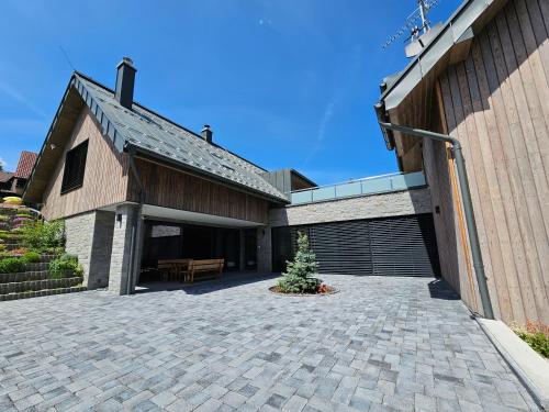 a house with a patio and a building at BudinSKI Apartmány & Wellness in Liptovský Mikuláš