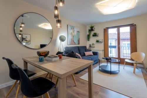 a living room with a table and a mirror at El Encanto del 12 by Unique Rooms in Burgos