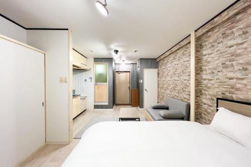 a bedroom with a large bed and a brick wall at Raffine Nihonbashi in Osaka