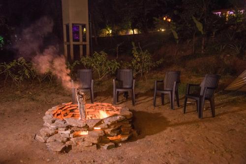 a fire pit with chairs around it at night at The New Crown Hotel in Dambulla
