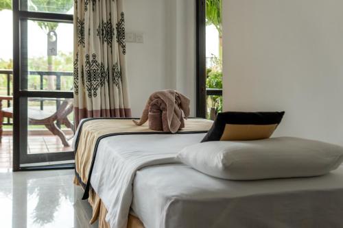 a bed with a stuffed elephant sitting on top of it at Ananthaya Beach in Tangalle