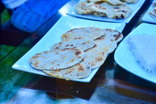 two trays of pancakes on a table with plates of food at The New Crown Hotel in Dambulla