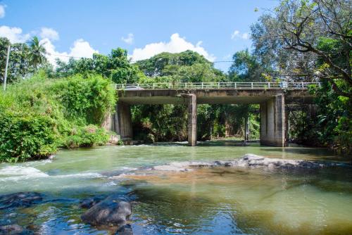 a bridge over a river with a rock in the water at The New Crown Hotel in Dambulla