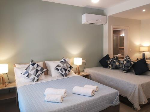 sypialnia z 2 łóżkami i ręcznikami w obiekcie Iris Studios Chios w mieście Karfas
