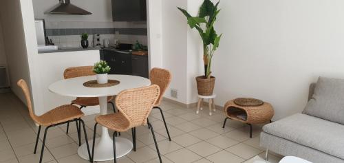 sala de estar con mesa, sillas y sofá en L'Appart' - ADRIAE Home, en LʼAiguillon-sur-Mer
