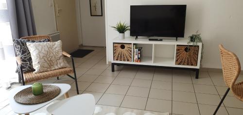 una sala de estar con TV de pantalla plana en un armario en L'Appart' - ADRIAE Home, en LʼAiguillon-sur-Mer