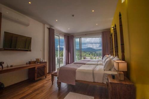a bedroom with a large bed and a large window at Morning Dew Boutique Hotel Ella in Ella