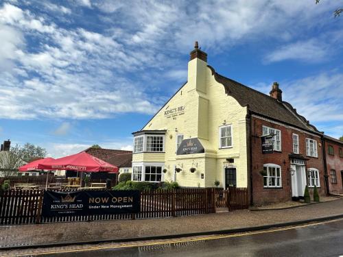 a building on the side of a street with a fence at Kings Head Coltishall in Norwich