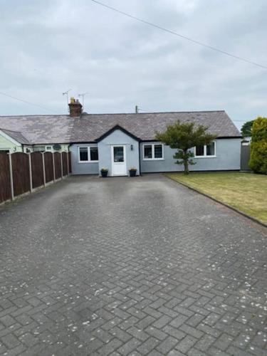 a white house with a fence and a driveway at Stunning Two bed cottage in Rhuddlan