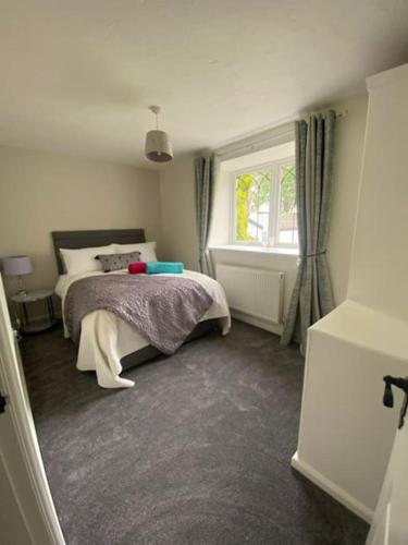 um quarto com uma cama e uma janela em Stunning Two bed cottage em Rhuddlan