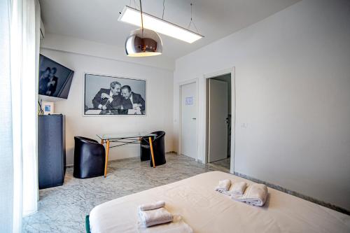 Un dormitorio con una cama y una mesa. en Splendida camera vista mare con terrazza e finiture di lusso en Marina di Carrara