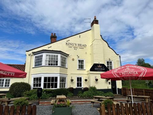 a white building with an umbrella in front of it at Kings Head Coltishall in Norwich