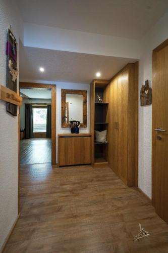 a living room with wooden cabinets and a hallway at Ferienwohnung Kobler in Landeck