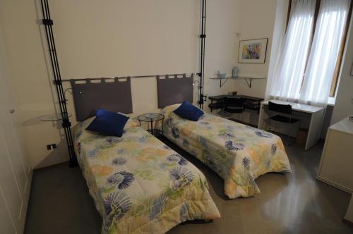 ミラノにあるレ コルティ ディ アロア ミラノのベッドルーム1室(枕付きベッド2台、デスク付)