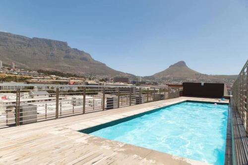 ein Pool auf einem Gebäude mit Bergen im Hintergrund in der Unterkunft Modern Apartment in Chapel Towers (with Inverter) in Kapstadt
