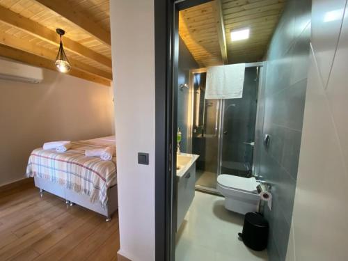 a bathroom with a bed and a shower and a toilet at Tinos Otel & Bağ Evi 12 Yaş Üstü in Bozcaada