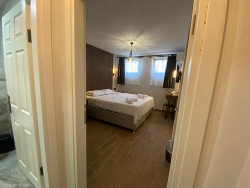 a small bedroom with a bed and a window at Tinos Otel & Bağ Evi 12 Yaş Üstü in Bozcaada