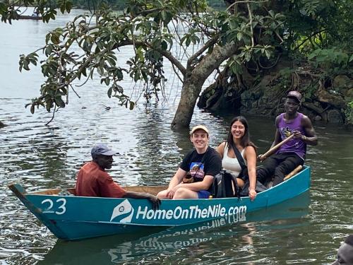 un grupo de personas sentadas en un barco azul en el agua en Home On The Nile Ernest Hemingway Suite, en Jinja