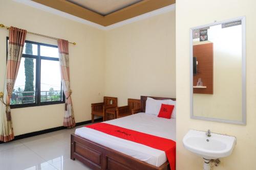 スラカルタにあるRedDoorz near Candi Sukuh Karanganyarのベッドルーム1室(ベッド1台、シンク、窓付)