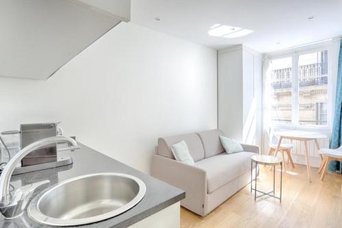 a white living room with a sink and a couch at Ciseaux 4F - Saint Germain des Prés in Paris