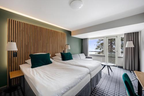 a hotel room with two beds and a window at Break Sokos Hotel Koli in Kolinkylä