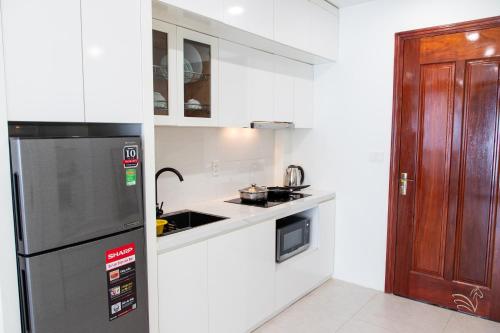a small kitchen with a refrigerator and a sink at Central Westlake Residence 2 - By Pegasy Group in Hanoi