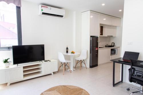 a white living room with a tv and a kitchen at Central Westlake Residence 2 - By Pegasy Group in Hanoi