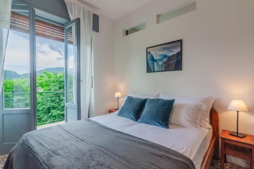 um quarto com uma cama e uma grande janela em Nel Verde di Rovenza by Wonderful Italy em Bellagio