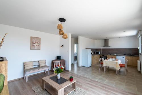 un salon avec une table et une cuisine dans l'établissement Logis de la Perruche - Maison avec terrasses, à Montreuil-Bellay