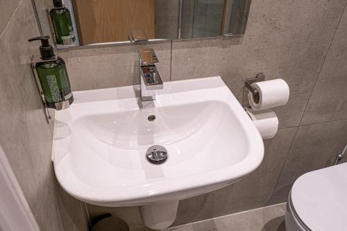 a bathroom with a white sink and a toilet at Maiden Oval in London