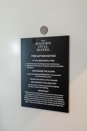 a sign on a wall with a fire action notice at Maiden Oval in London