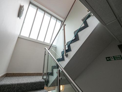 a staircase in a building with a glass railing at Maiden Oval in London