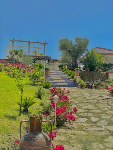 a garden with pink flowers and stairs in the background at L'incanto di Nausicaa in Ascea