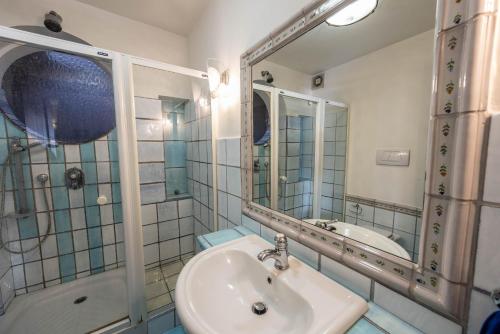 a bathroom with a sink and a shower and a mirror at Villa Patrizia in Minturno