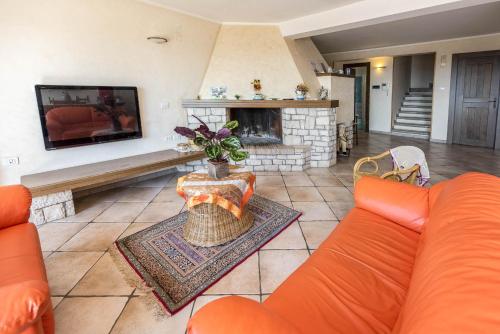 a living room with an orange couch and a fireplace at Villa Patrizia in Minturno
