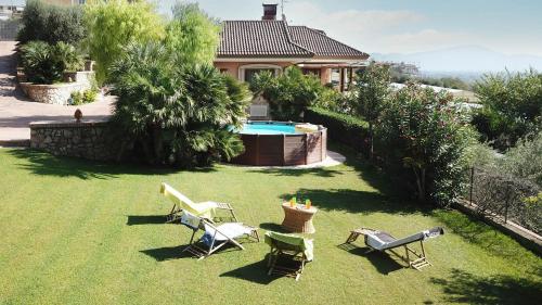 a yard with chairs and a pool and a house at Villa Patrizia in Minturno