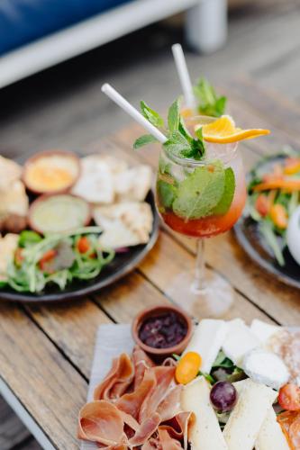 a table topped with plates of food and a drink at Hôtel & Appartements Monsigny in Nice