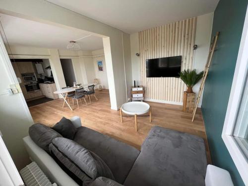 a living room with a couch and a table at Superbe appartement proche de la plage in Dunkerque
