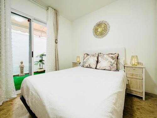 Habitación blanca con cama y ventana en Oyansa Apartments en Vilanova i la Geltrú