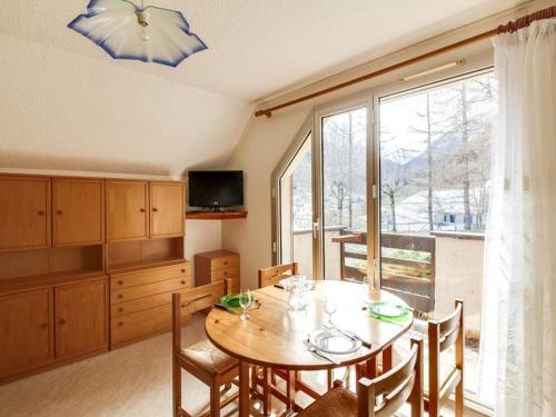 une salle à manger avec une table et une grande fenêtre dans l'établissement Duplex cosy pour 5 pers., balcon sud, parking, proche centre et remontées, navette hivernale - FR-1-401-82, à Cauterets