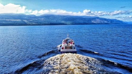 a boat in the middle of a large body of water at Loch Ness Clansman Hotel in Drumnadrochit